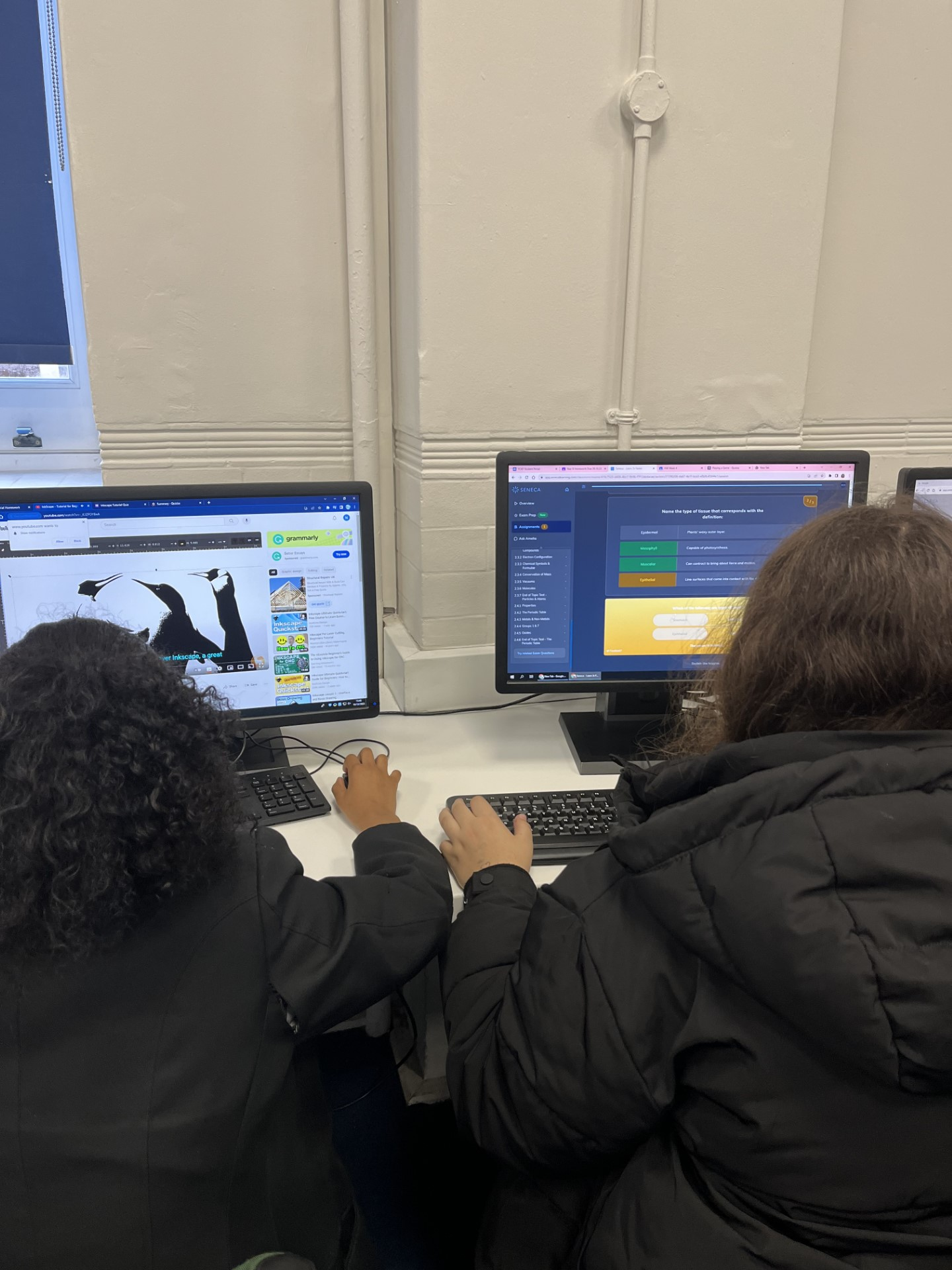 Two young people working on educational activities at computers